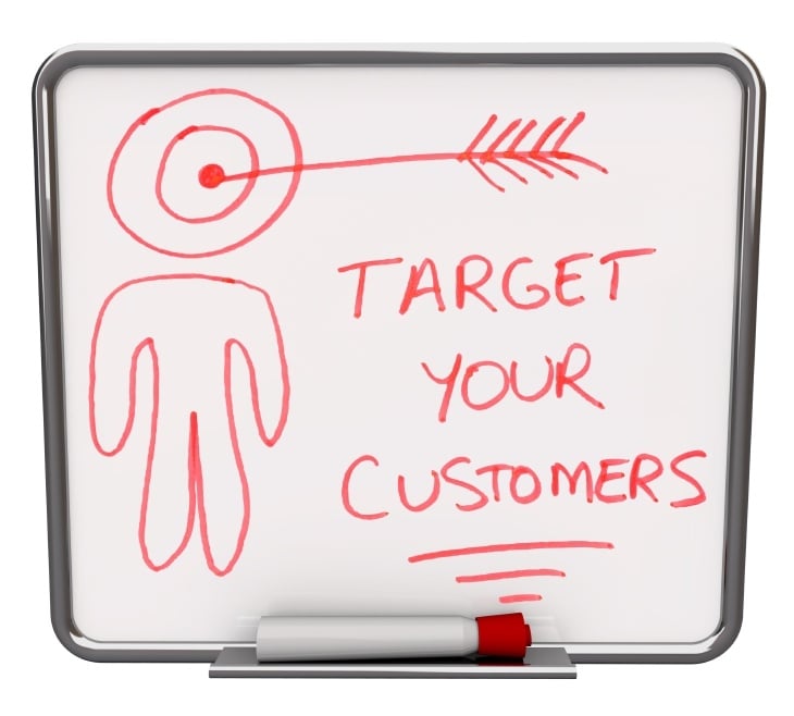 A white dry erase board with red marker, with the words Target Your Customers