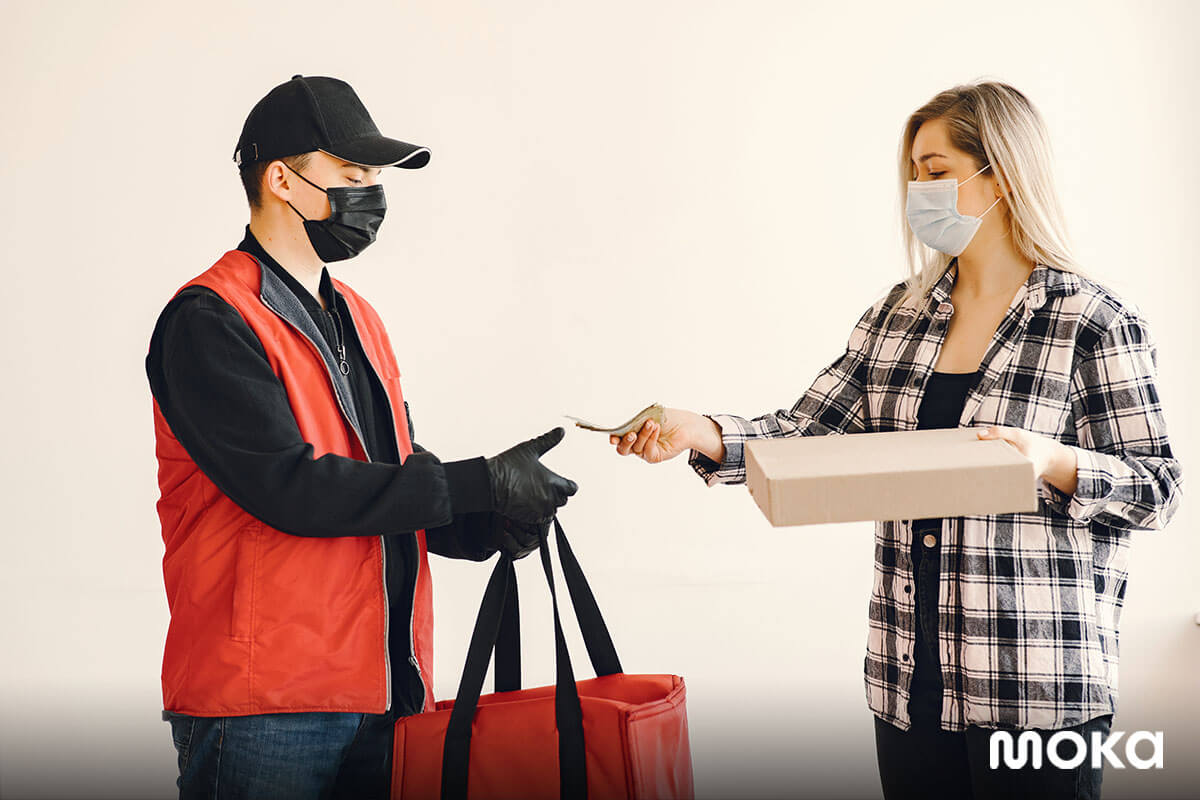 pelanggan menggunakan masker ketika mengambil online delivery dari gofood